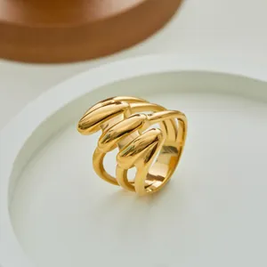 Detailopname van een gepolijste gouden geometrische ring met golvende lijnen