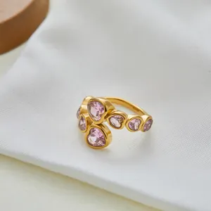 Macro-detail van gouden open ring met gepolijste roze hartvormige kristallen edelstenen