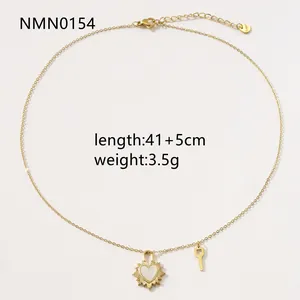 Detalle de colgante de corazón con nácar blanco y llave dorada en una cadena fina