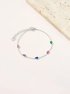 Macro detail van de zilveren roestvrijstalen armband met vijf gekleurde druppelvormige zirkoon