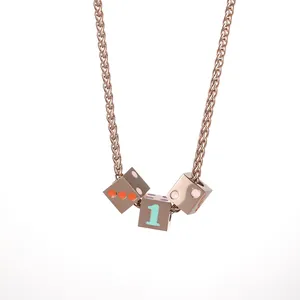 Detailed macro view of rose gold dice pendant with number one and colorful dots
