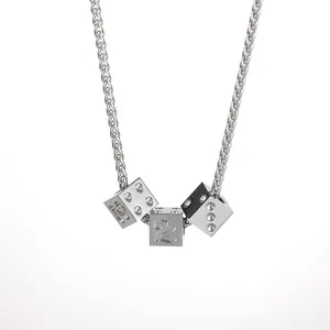 Macro detail of silver titanium steel necklace featuring three engraved dice cube pendants