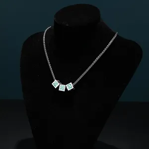 Macro view of silver titanium steel wheat chain necklace with green dice pendants