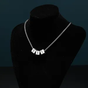 Detailed view of silver titanium dice pendant with number 1 on a wheat chain