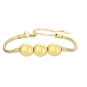 Détail du bracelet chaîne serpent dorée avec le chiffre un gravé sur des perles rondes