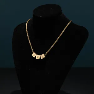 Detail of gold titanium steel chain featuring three dice pendants with number one engraving