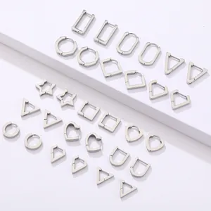 Pendientes geométricos de acero inoxidable plateado pulido en escalones blancos