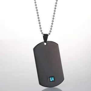 Primer plano del colgante rectangular negro mate con gema azul y cadena de bolas plateada