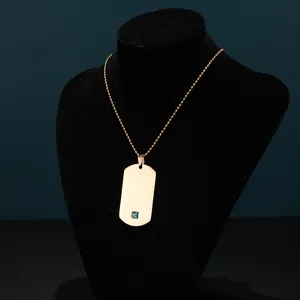 Detalle del collar de placa rectangular dorada con gema azul en maniquí de cuello