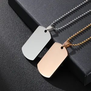 Vista macro de colgantes dog tag en plata y oro rosa sobre fondo de cuero negro texturizado
