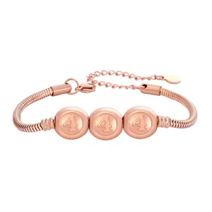 Détail d'un bracelet maille serpent en or rose avec perles gravées du chiffre quatre