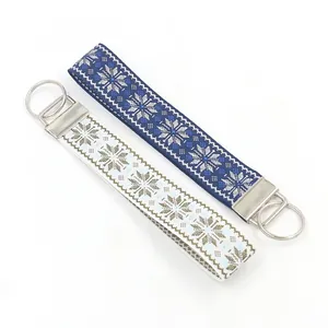Ethnic style woven keychains with geometric snowflake pattern in navy and beige colors