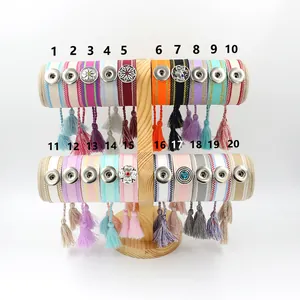 Pulseras bohemias tejidas con botones de presión metálicos y borlas en exhibidor