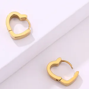Primer plano de pendientes huggie de corazón en acero inoxidable bañado en oro 18K
