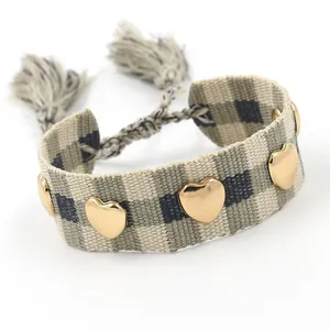 Pulsera de la amistad tejida con tachuelas de corazón doradas y patrón de cuadros verde negro