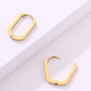 Detalle de pendientes rectangulares de acero inoxidable bañados en oro de 18K pulido