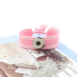 Détail macro du bracelet à bouton-pression NOOSA rose tissé avec franges décoratives