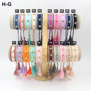 Collection of handmade braided friendship bracelets with golden heart charms and tassels