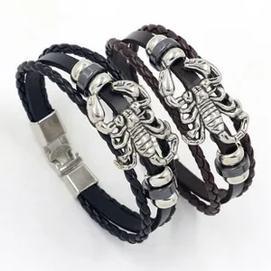 Macro detail of multi-layer leather bracelets with engraved silver scorpion charm