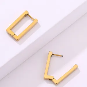 Detalle de pendientes rectangulares dorados con acabado cepillado sobre fondo blanco
