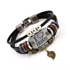 Detail of vintage leather bracelet with I Love Jesus metal plaque and leaf pendant