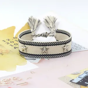 Macro-opname van een geweven vriendschapsarmband met zilveren sternagels en kwastjes