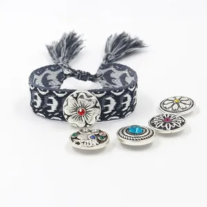 Detalle de pulsera bohemia tejida con botones a presión y dijes florales de metal vintage