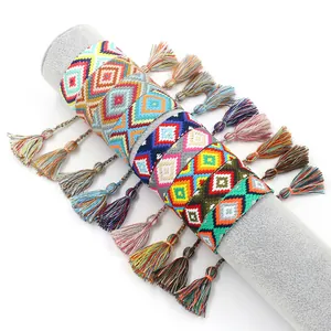 Pulseras de la amistad tejidas étnicas con borlas de colores en soporte de joyas