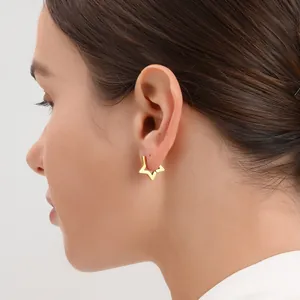 Pendientes de estrella de acero inoxidable bañados en oro de 18K en una modelo
