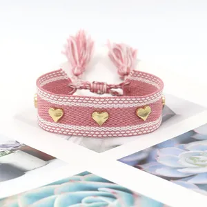 Braccialetto dell'amicizia intrecciato rosa con rivetti a cuore dorati e nappe regolabili
