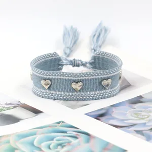 Bracelet tissé bleu clair avec cœurs argentés et liens réglables à glands