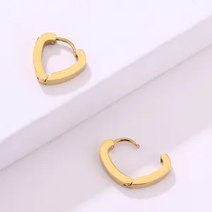 Primer plano de aretes de aro de corazón chapados en oro de 18K sobre soporte blanco