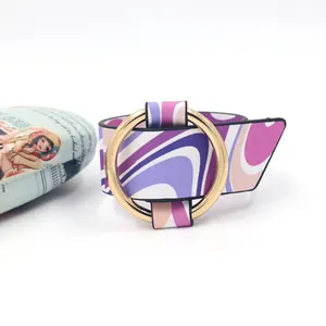 Macro detail of wide PU leather bracelet with purple wave patterns and gold round buckle