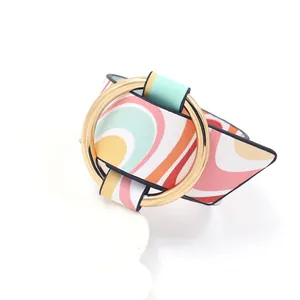 Macro view of colorful wavy PU leather wide cuff bracelet with polished gold metal ring