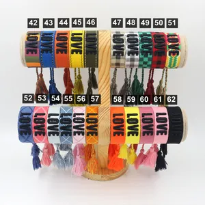 Detailed view of adjustable woven friendship bracelets with LOVE embroidery and tassels