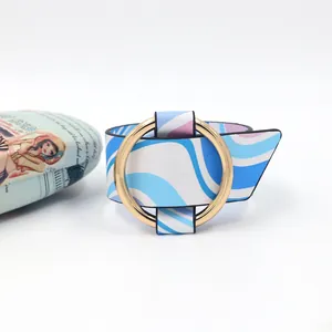 Detailed view of the bright gold metal ring clasp on a wavy print leather wide bracelet