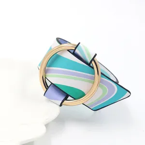 Detail of colorful wavy PU leather wide bangle with large polished gold metal ring buckle