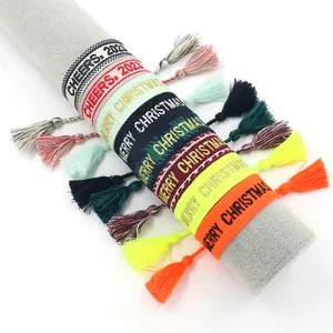 Close-up of woven cotton wristbands with festive Cheers and Merry Christmas embroidery