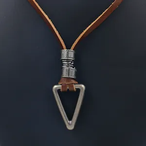Macro del ciondolo triangolare retrò con cordino in cuoio marrone e filo metallico