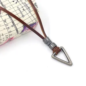 Dettaglio di pendente geometrico in bronzo su collana in pelle marrone scuro