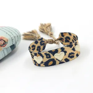 Vue détaillée du bracelet en toile léopard avec broderie cœur 3D et finitions à franges