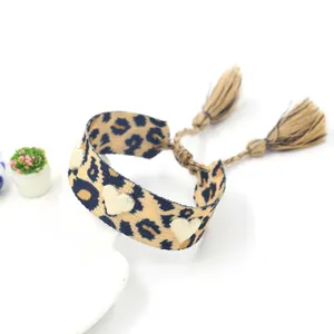 Détail du cœur brodé sur le bracelet tissé léopard avec glands réglables