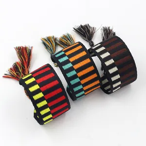 Close-up of woven ethnic friendship bracelets with colorful stripes and tassel details