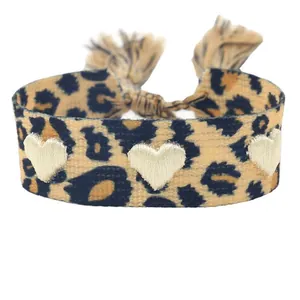 Bracelet imprimé léopard sauvage avec broderie cœur dorée et fermoir à glands