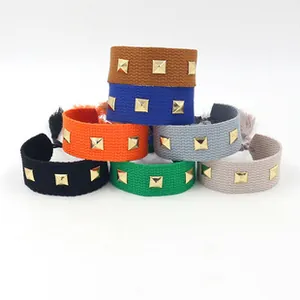 Close-up of woven ethnic friendship bracelets with metal studs and tassel details