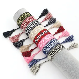 Bohemian embroidered tassel friendship bracelet featuring Vaccinated lettering text