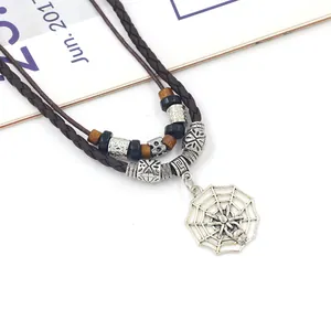 Detalle de collar multicapa de cuero trenzado con colgante de telaraña plateada