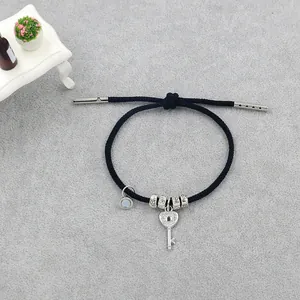 Bracelet ajustable en corde noire avec pendentif clé et perles de fleurs argentées