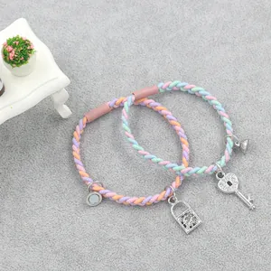 Detail of colorful braided friendship bracelets with magnetic heart key and lock charms