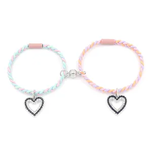 Matching magnetic woven couple bracelets with heart pendants in vibrant rainbow colors